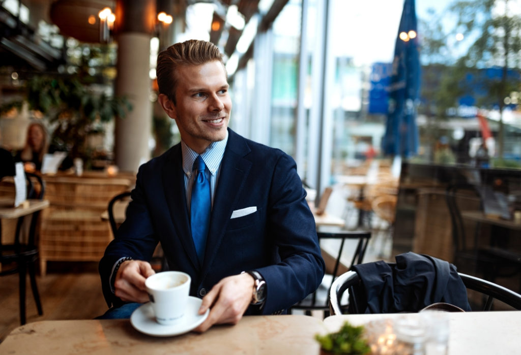 suited man drinking coffee