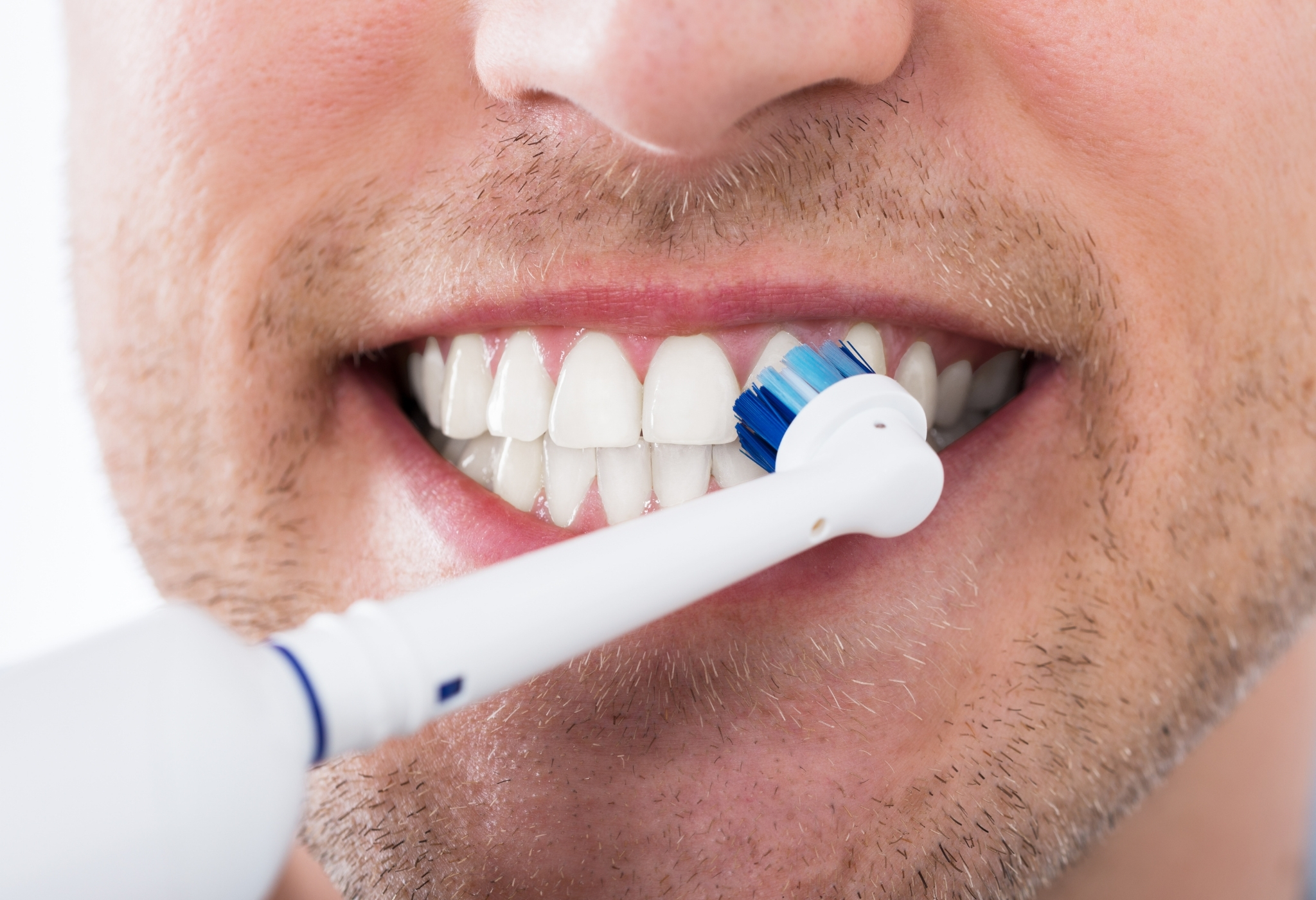 man brushing teeth with electric brush 