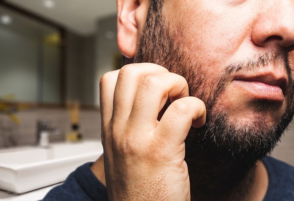 Man itching beard